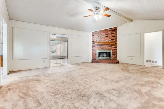 an empty room with windows and fireplace