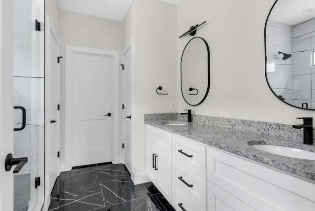 a bathroom with a granite countertop sink and a mirror