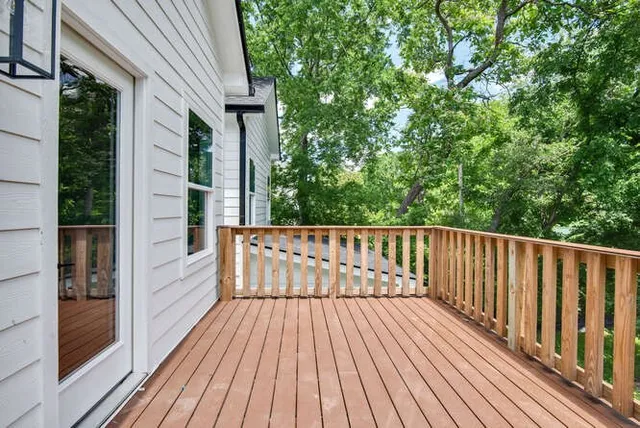 a balcony with wooden floor and yard in the back