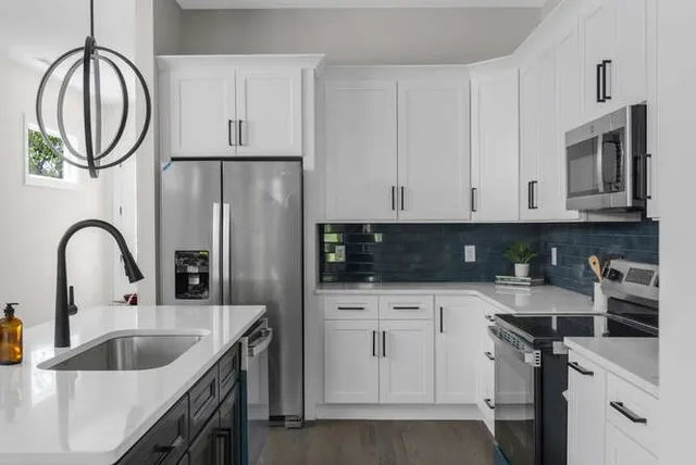 a kitchen with stainless steel appliances granite countertop a sink a stove and cabinets