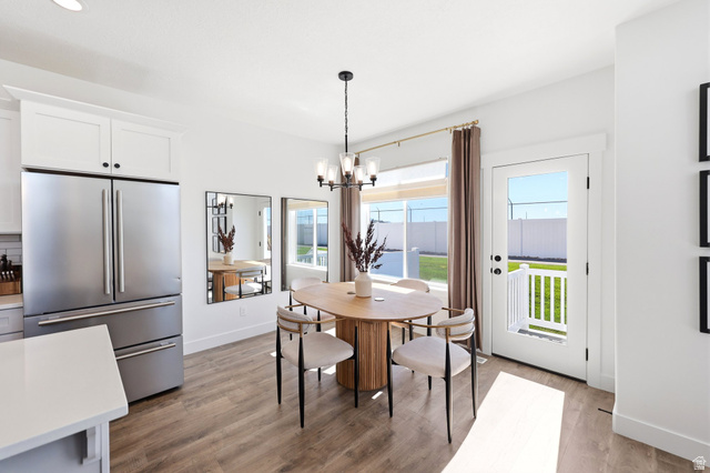 4646 Alder Drive, Unit 223 Mapleton, UT 84664 - Photo 19 of 35 Dining area featuring wood-finish flooring, a contemporary chandelier, and white trim