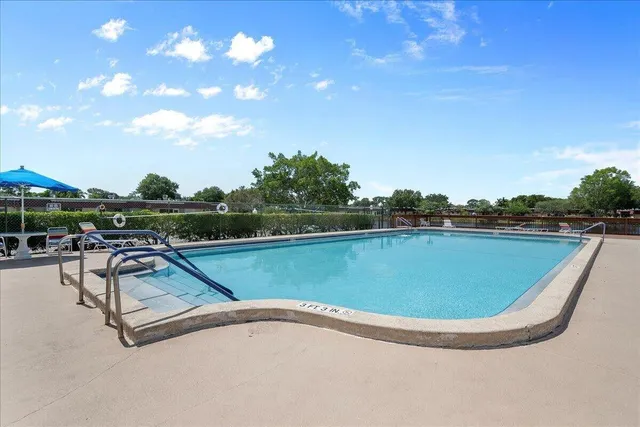 a view of a swimming pool with a yard and sitting space