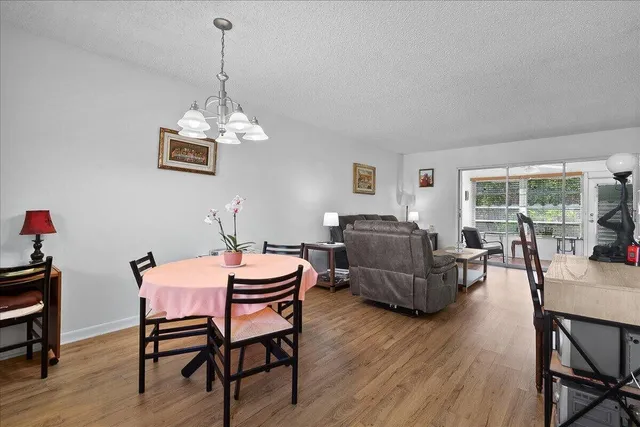 a dining room with furniture a chandelier and wooden floor