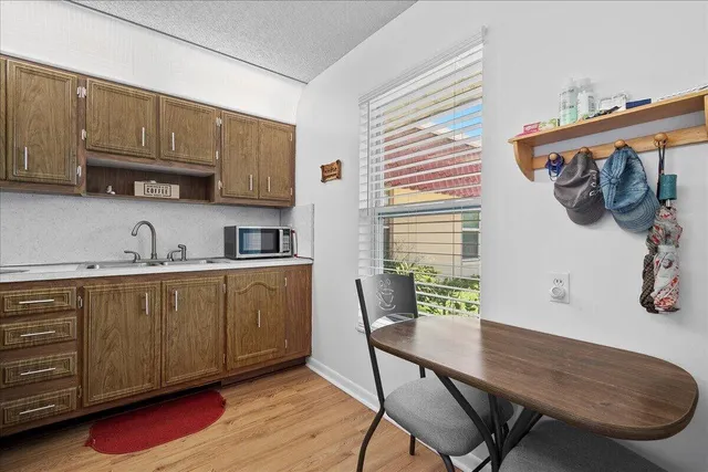 a kitchen with stainless steel appliances kitchen island granite countertop a table chairs in it and wooden floors