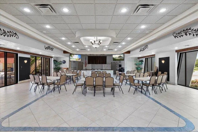 a large room with lots of furniture a chandelier and a rug