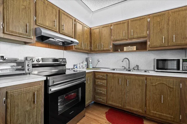 a kitchen with stainless steel appliances granite countertop a sink a stove and cabinets