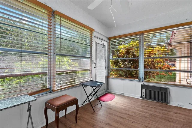a view of a room with a large window and wooden floor