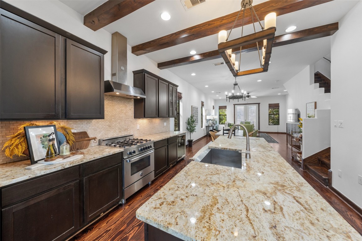 2601 Bevis Street, Unit E Houston, TX 77008 - Photo 19 of 47 Beautifully appointed chef’s kitchen featuring granite
countertops, a large island with farmhouse sink,
stainless steel appliances, and rich cabinetry.
Exposed wood ceiling beams and warm finishes add
character while the open layout flows seamlessly into
the living and dining areas—perfect for entertaining.