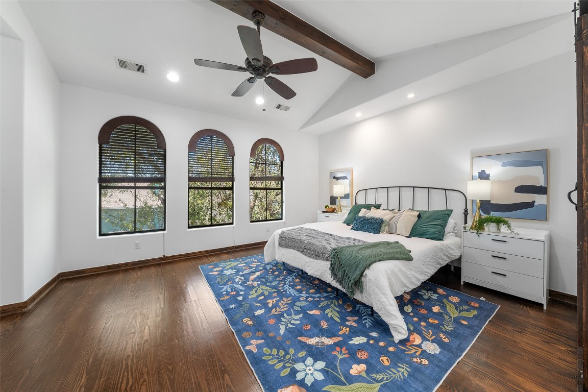 2601 Bevis Street, Unit E Houston, TX 77008 - Photo 23 of 47 Spacious third-floor primary suite featuring rich
wood floors, a vaulted ceiling with exposed beam,
and elegant arched windows that fill the room with
natural light. A peaceful retreat offering both
character and generous space to unwind.