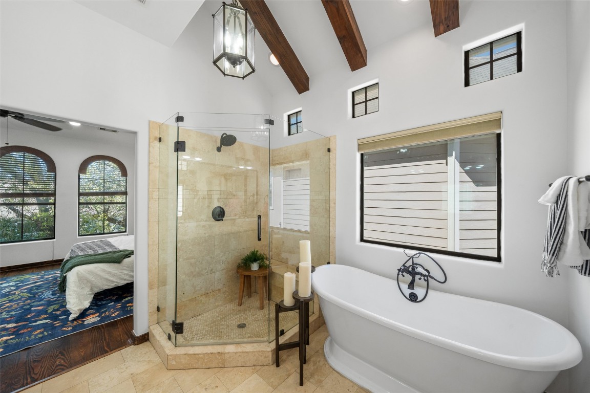 2601 Bevis Street, Unit E Houston, TX 77008 - Photo 24 of 47 Spa-inspired primary bathroom featuring a
freestanding soaking tub, spacious glass-
enclosed shower, and vaulted ceiling with
exposed beams. Natural light and elegant
finishes create a relaxing retreat just off the
primary suite.