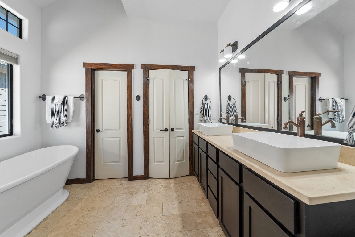 2601 Bevis Street, Unit E Houston, TX 77008 - Photo 25 of 47 Spacious primary bathroom featuring dual vessel
sinks, granite countertops, and rich cabinetry.
The thoughtful layout includes a freestanding
soaking tub and private access to the walk-in
closet for added convenience.