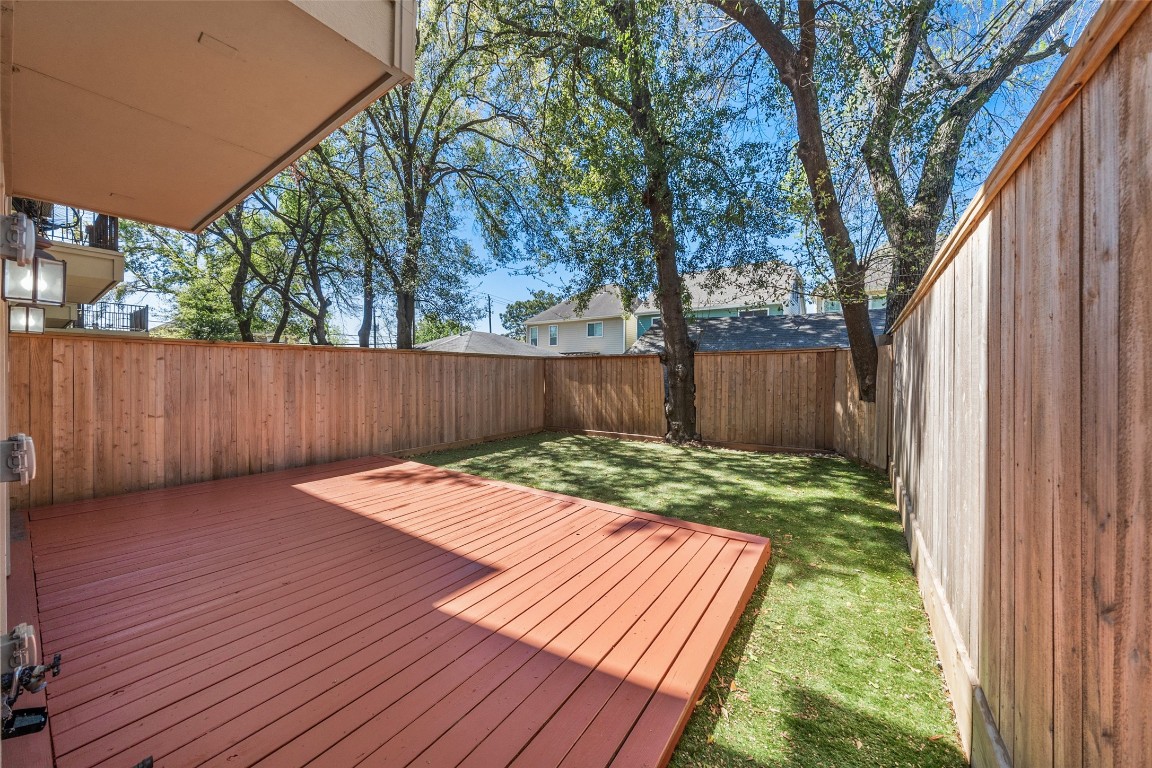 2601 Bevis Street, Unit E Houston, TX 77008 - Photo 32 of 47 Private backyard featuring a spacious deck perfect for
outdoor dining and entertaining, along with a low-
maintenance yard ideal for relaxing or pets. Surrounded by a
tall privacy fence and mature trees, this outdoor space
offers both comfort and seclusion.