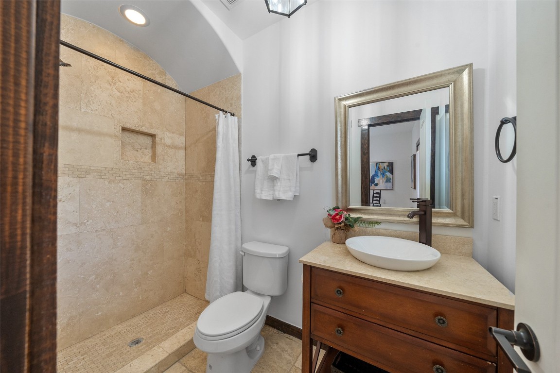 2601 Bevis Street, Unit E Houston, TX 77008 - Photo 5 of 47 Well-appointed first-floor bathroom featuring a spacious
walk-in shower with tile surround and arched detail,
complemented by a stylish vanity with vessel sink and
warm wood cabinetry. A convenient and private bath
ideal for guests or the first-floor bedroom suite.