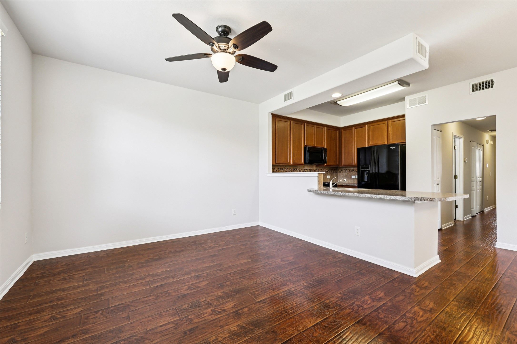 1524 Sanders Kyle, TX 78640 - Photo 5 of 37 Kitchen featuring black appliances, a peninsula, wood finish cabinetry, ceiling fan, and dark wood-style flooring