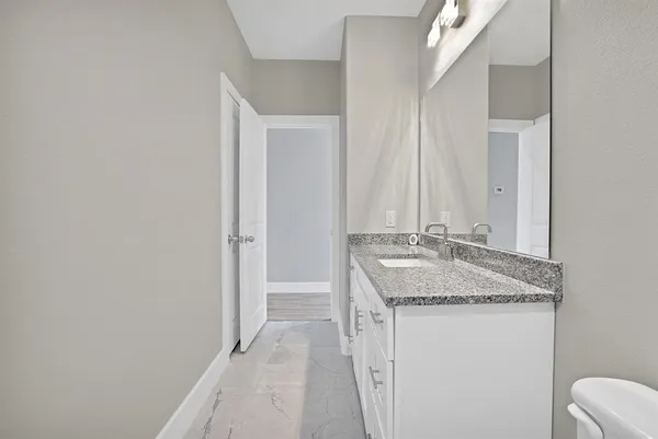 a bathroom with a granite countertop sink and a mirror