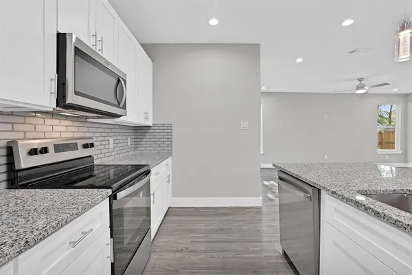 a kitchen with stainless steel appliances granite countertop a sink stove and microwave