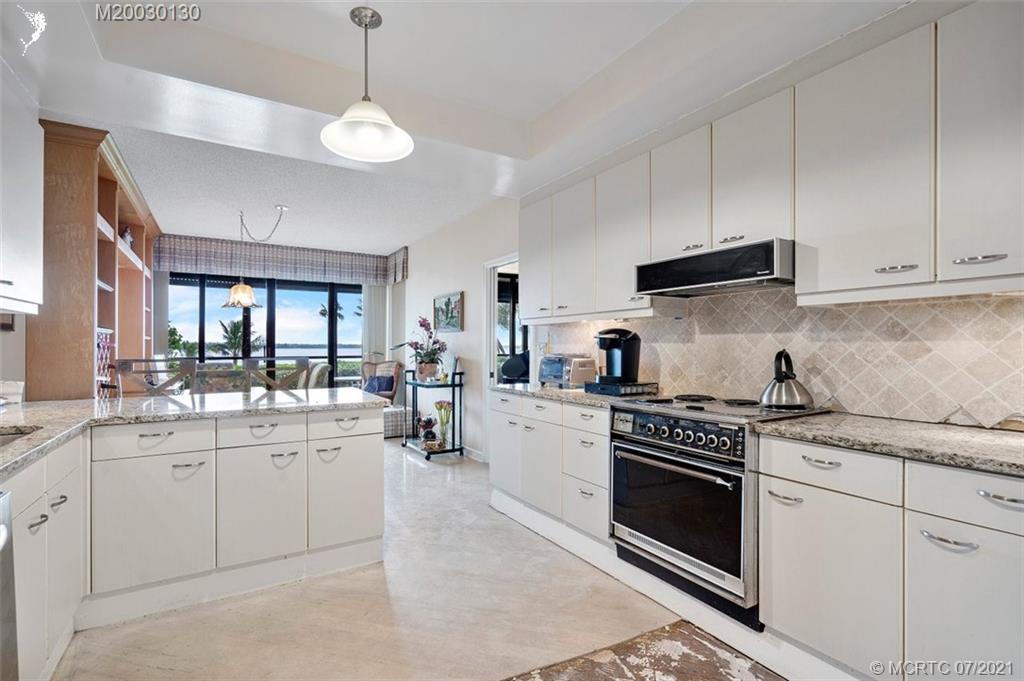2824 Southeast Dune Drive, Unit 2102 Jensen Beach, FL 34957 - Photo 11 of 40 a kitchen with a stove sink and cabinets