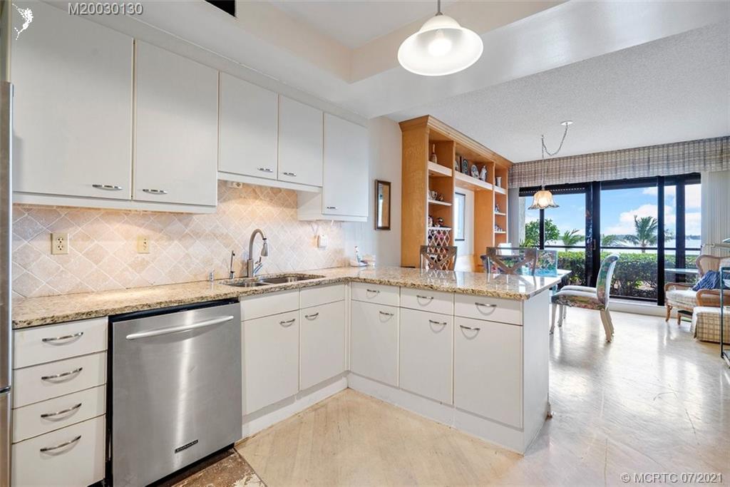 2824 Southeast Dune Drive, Unit 2102 Jensen Beach, FL 34957 - Photo 13 of 40 a kitchen with granite countertop a sink and cabinets