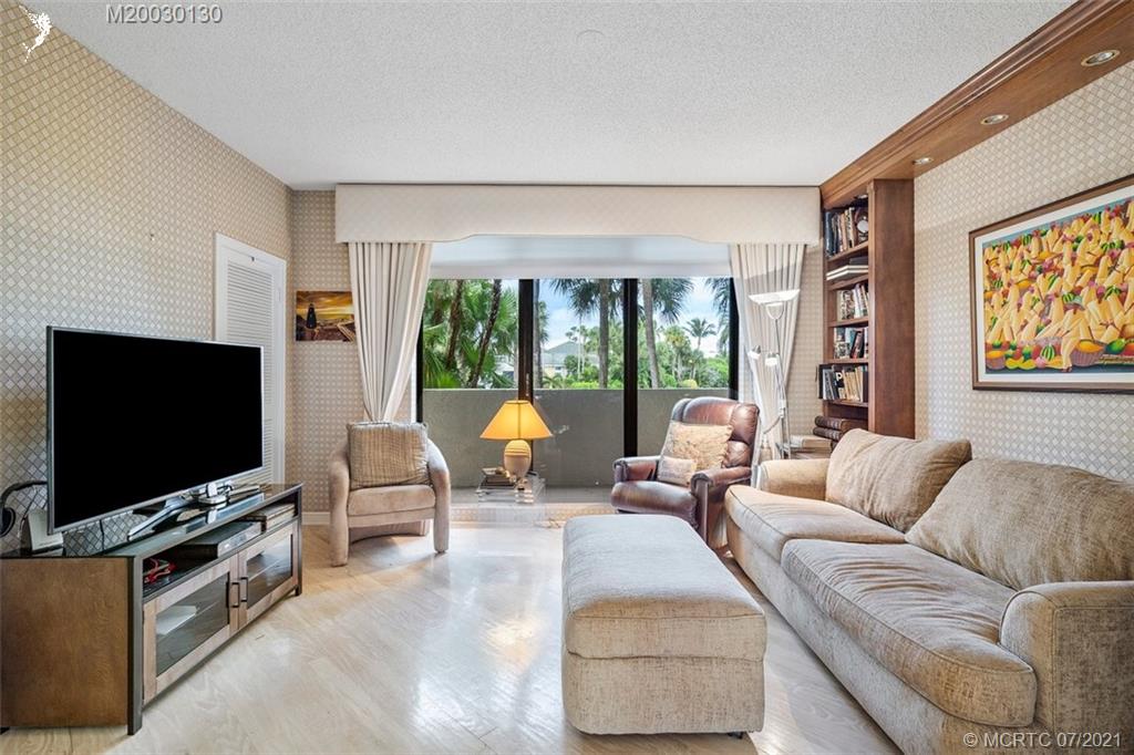 2824 Southeast Dune Drive, Unit 2102 Jensen Beach, FL 34957 - Photo 16 of 40 a living room with furniture and a flat screen tv