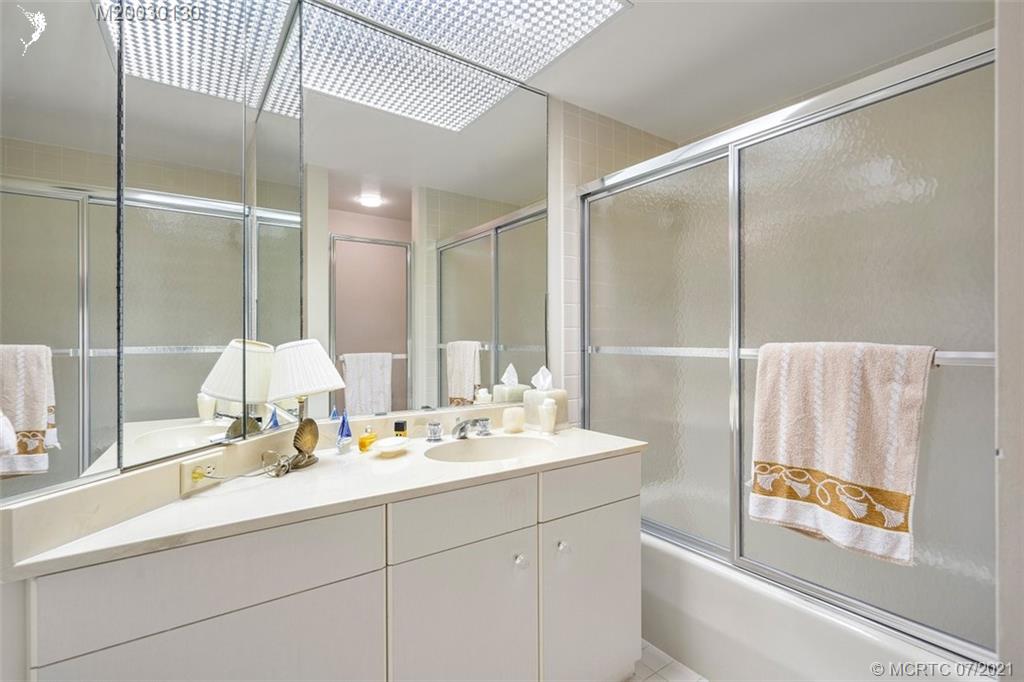 2824 Southeast Dune Drive, Unit 2102 Jensen Beach, FL 34957 - Photo 17 of 40 a bathroom with a double vanity sink and mirror