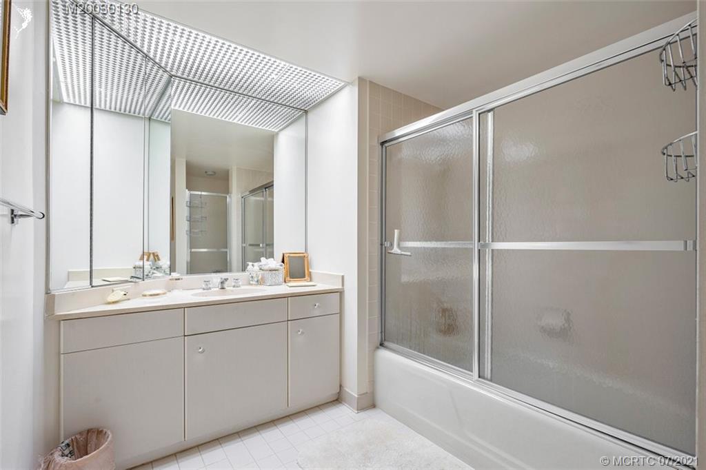 2824 Southeast Dune Drive, Unit 2102 Jensen Beach, FL 34957 - Photo 19 of 40 a bathroom with a double vanity sink and mirror with shower