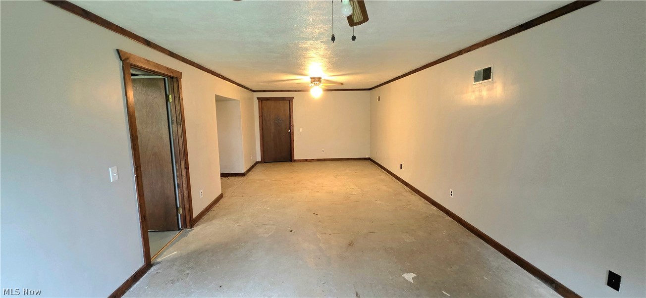 252 Saxe Road Mogadore, OH 44260 - Photo 22 of 24 Spacious room featuring light-toned walls, dark wood-finish trim, and a ceiling fan with integrated lighting