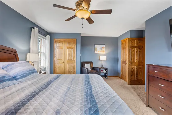 a bedroom with a large bed and a chandelier