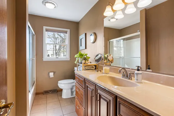 a bathroom with a sink a toilet and a mirror