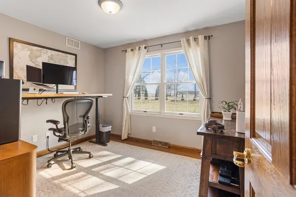 a view of a workspace with furniture and a window