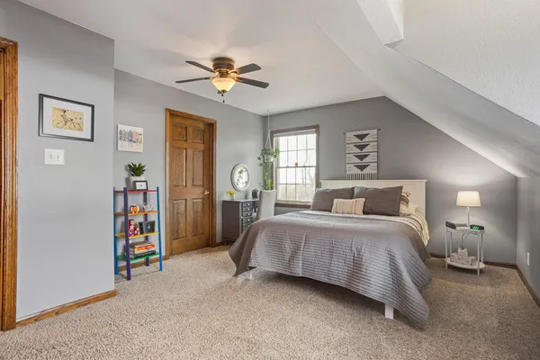 a spacious bedroom with a bed and a chandelier