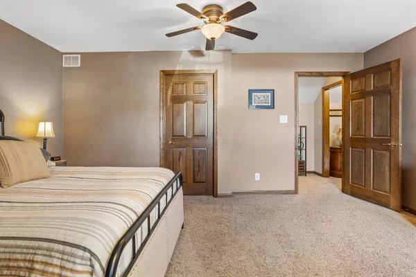 a bedroom with a large bed and a chandelier