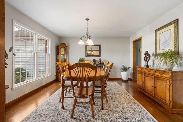 a dining room with furniture a chandelier and wooden floor