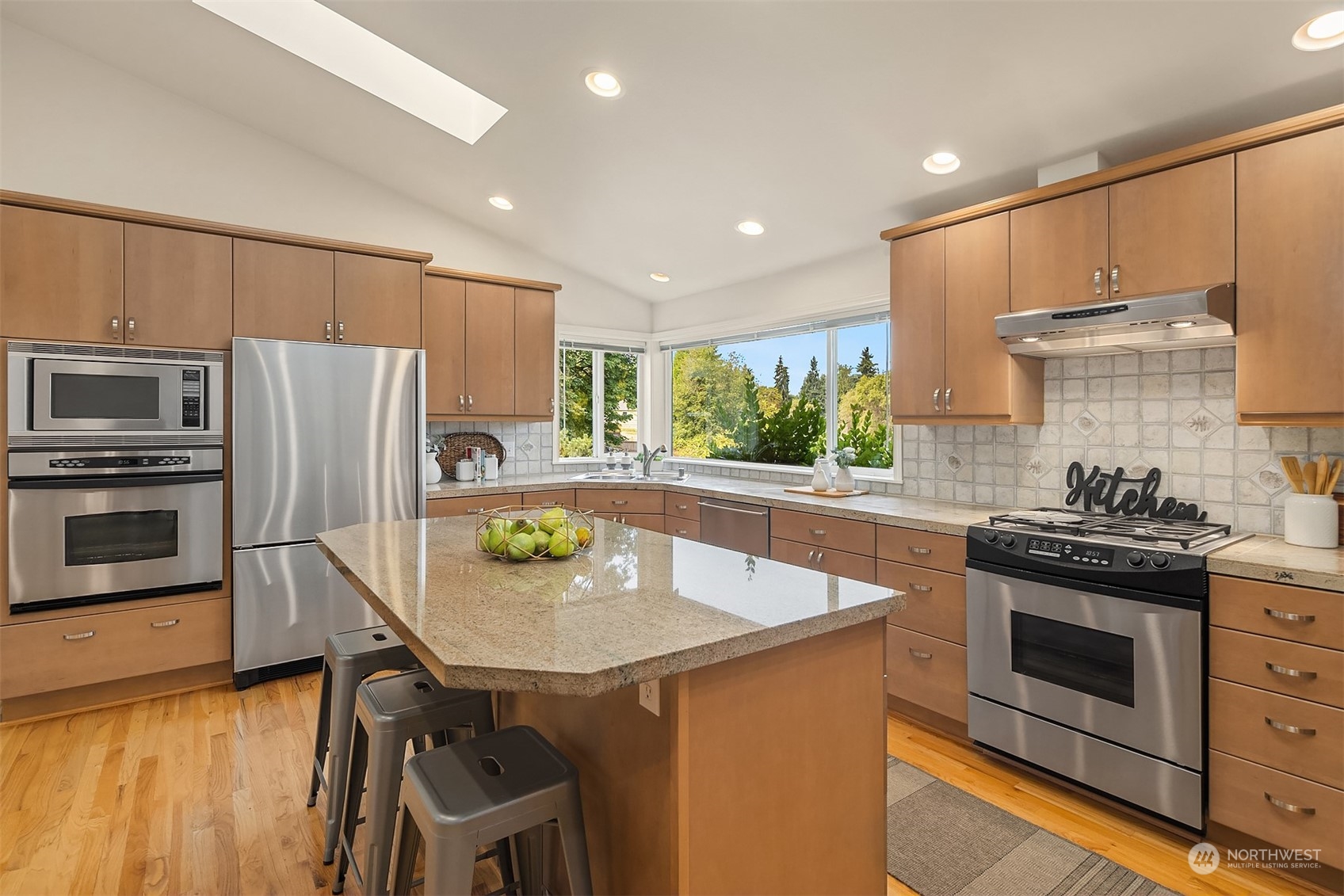 11302 East Riverside Drive Bothell, WA 98011 - Photo 12 of 37 a kitchen with stainless steel appliances a stove a sink a microwave a refrigerator and cabinets