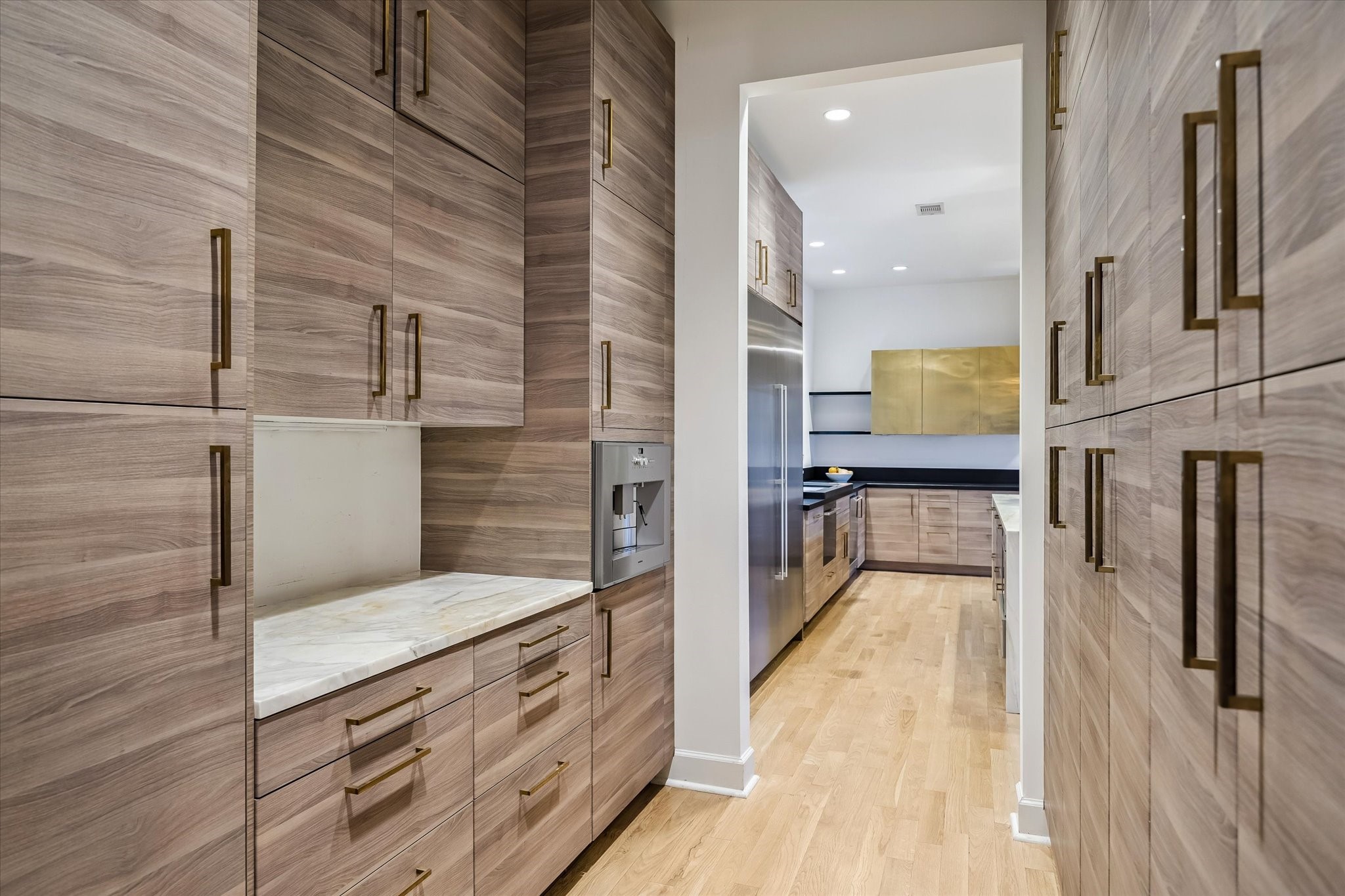 3706 Tangley Street Houston, TX 77005 - Photo 14 of 50 Just off the dining room, the butler’s pantry pairs function with elevated design. Marble countertops, custom pull-out storage, and a Gaggenau built-in coffee maker create a space that’s as refined as it is practical. It’s a hidden layer of luxury that makes entertaining feel seamless.
