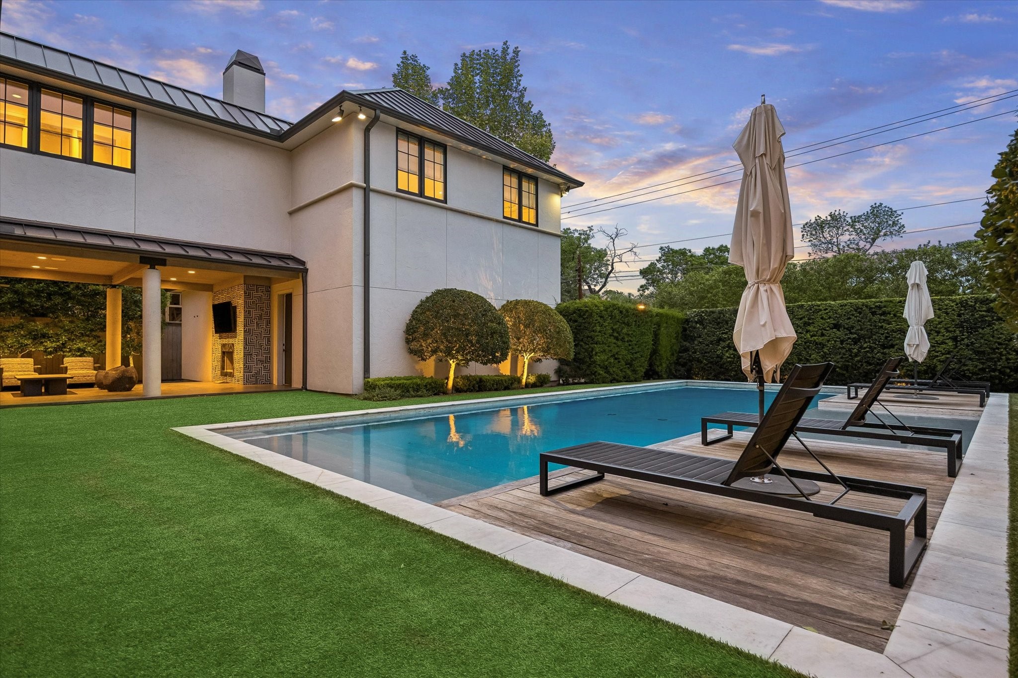 3706 Tangley Street Houston, TX 77005 - Photo 2 of 50 Framed by the covered patio and thoughtfully designed outdoor areas, the pool invites both quiet retreat and entertaining. The layout balances open space with defined gathering zones, enhancing both function and flow. It’s a backyard experience that reflects the essence of modern luxury living—where design and lifestyle come together.