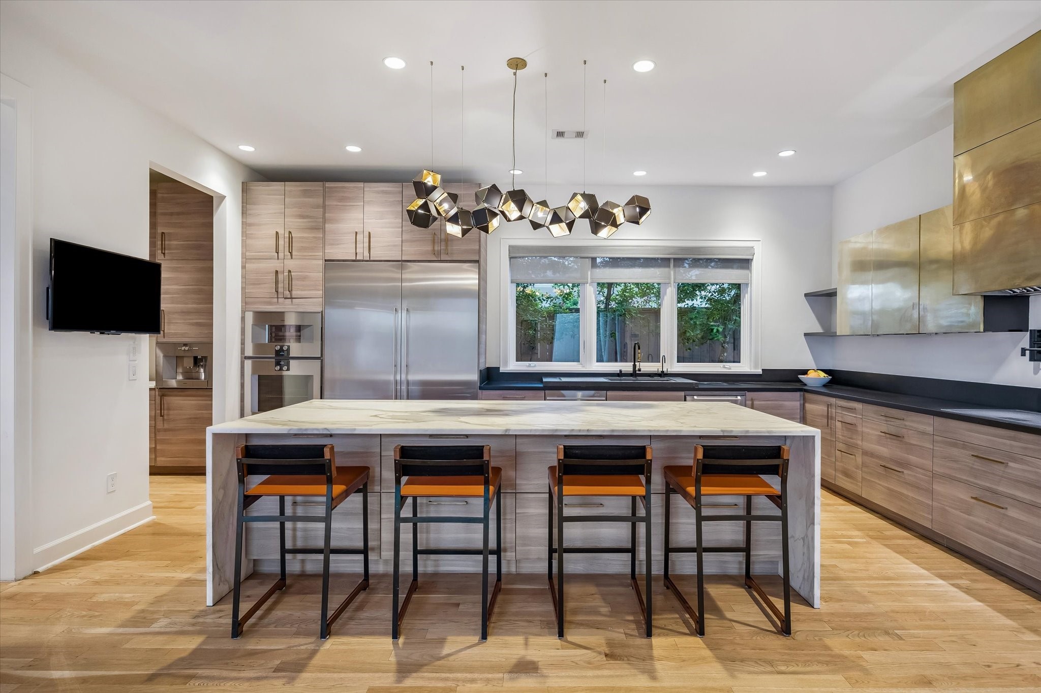 3706 Tangley Street Houston, TX 77005 - Photo 21 of 50 A generous marble island serves as the natural gathering point, offering both prep space and connection. Integrated details like under-cabinet lighting, in-ceiling speakers, and a Waterstone faucet elevate both function and experience. Every element feels considered and intentional.