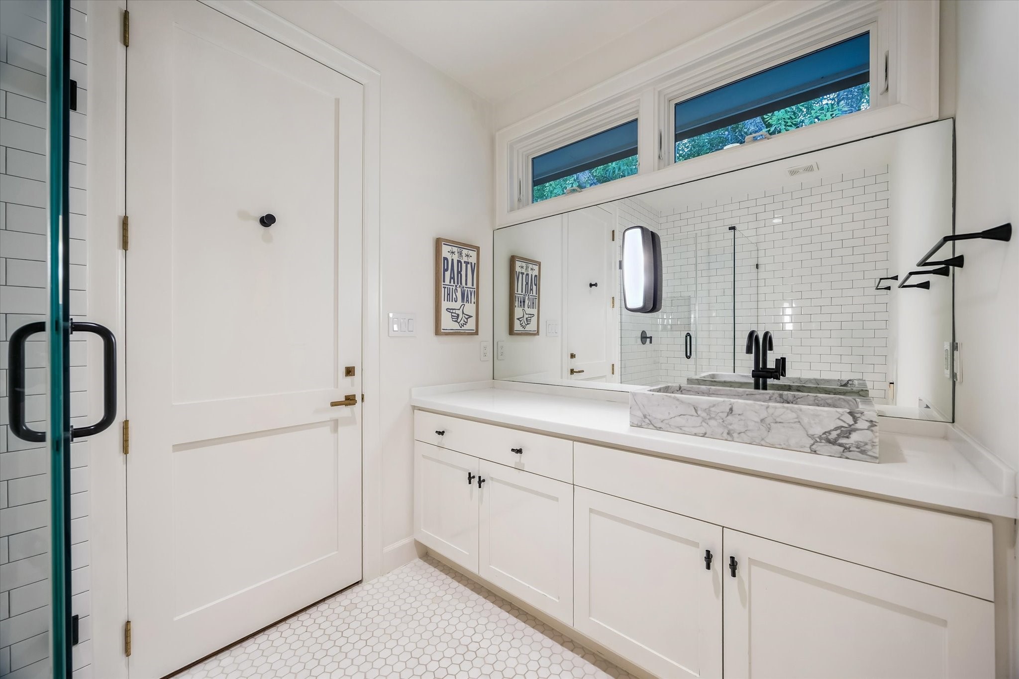 3706 Tangley Street Houston, TX 77005 - Photo 34 of 50 Serving Guest Bedroom No. 1, this bathroom pairs white stone countertops with a marble vessel sink and black-toned hardware. Hexagonal mosaic tile flooring adds texture, while a Toto washlet enhances functionality. The shower is finished with white penny tile and subway tile for a clean, timeless look.