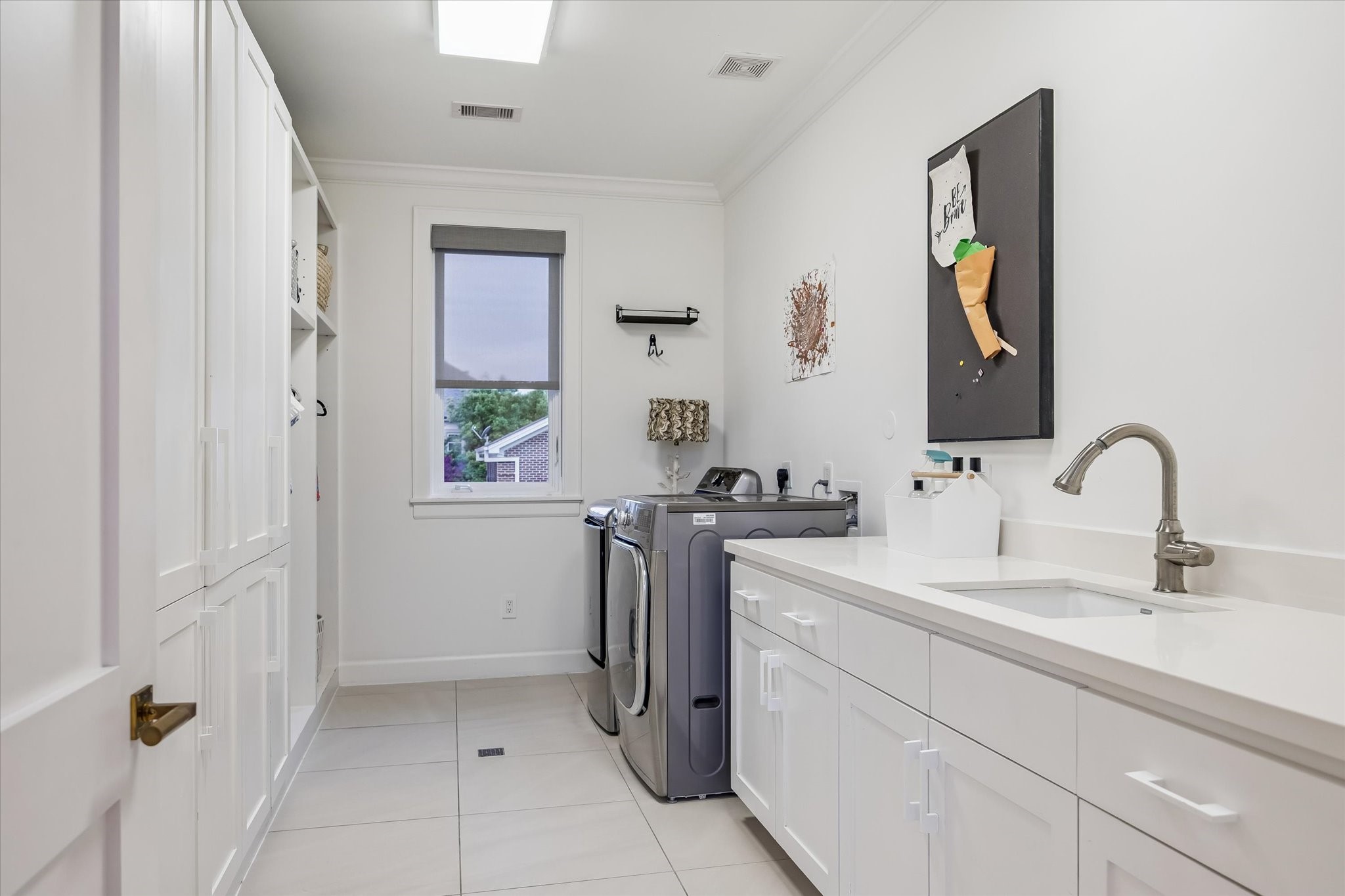 3706 Tangley Street Houston, TX 77005 - Photo 41 of 50 Designed for efficiency, the utility room features an LG front-load washer and dryer with ample built-in storage. A Blanco sink and countertop workspace add practicality for daily tasks. Windows, LED lighting, and attic access complete this highly functional space.