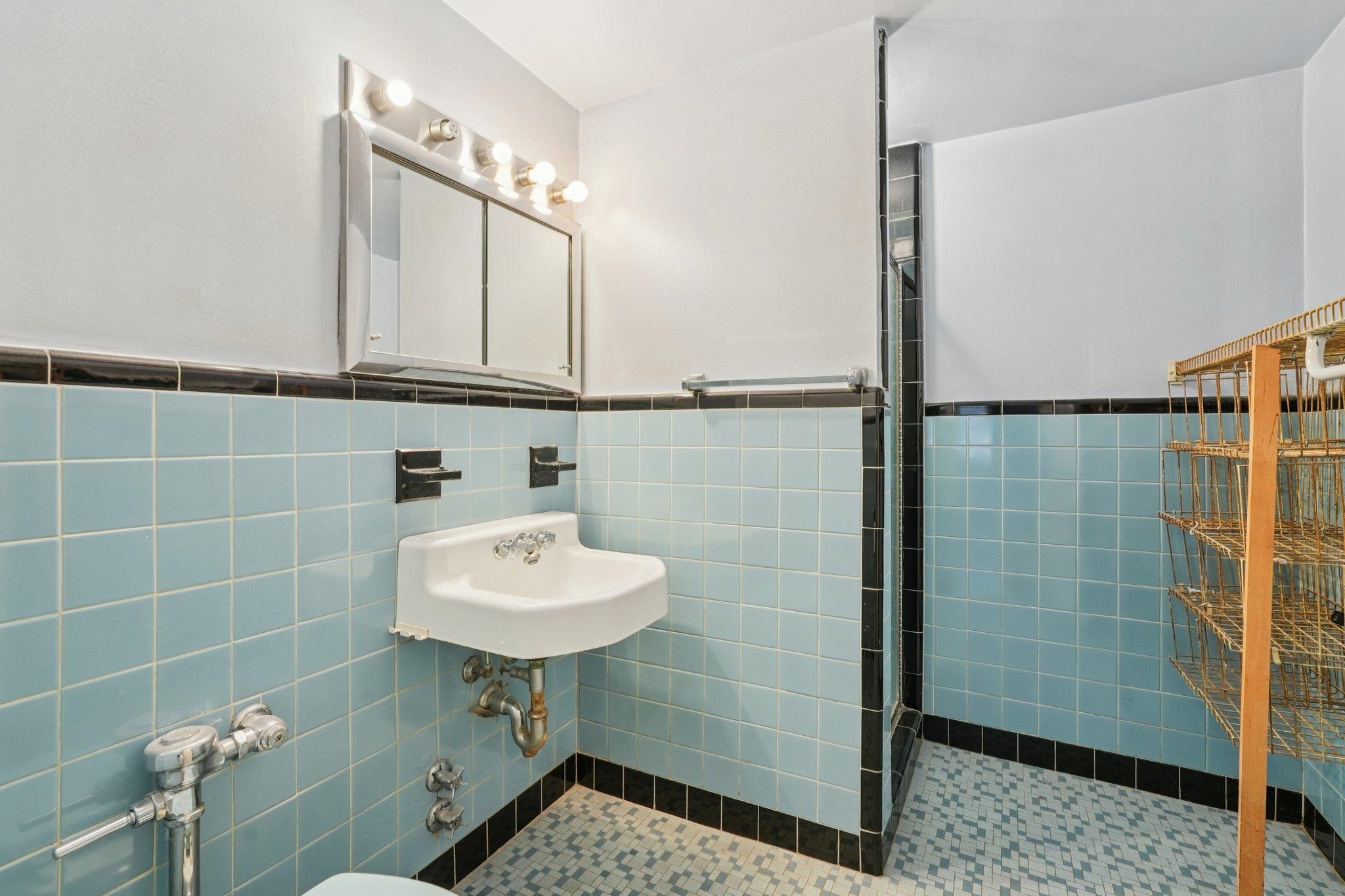 6010 Boulevard East, Unit 54 West New York, NJ 07093 - Photo 17 of 20 a bathroom with a sink a mirror and shower