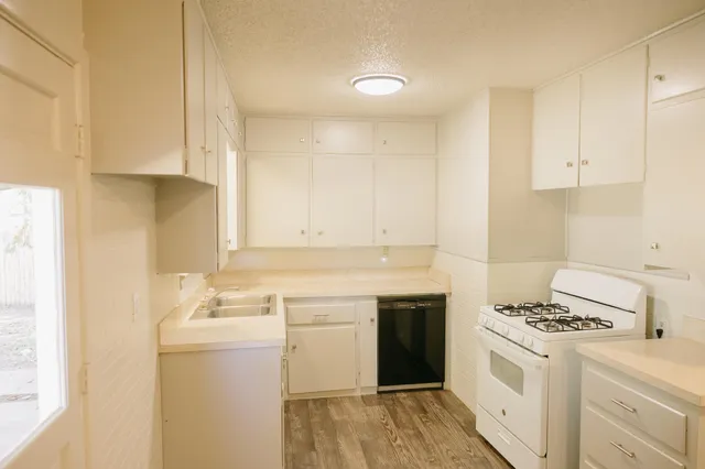 a kitchen with a sink stove and cabinets