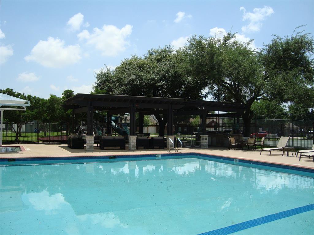 814 Broken Feather Trail Pflugerville, TX 78660 - Photo 24 of 24 An inviting outdoor community area features a sparkling pool and a shaded lounge with mature trees.