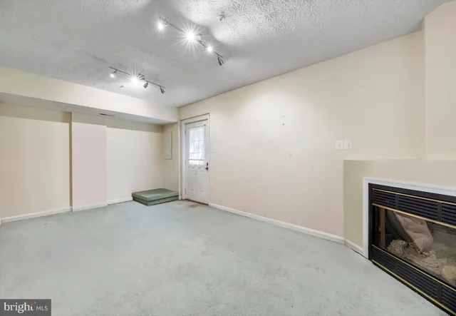 a view of an empty room with closet and a fireplace