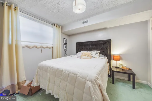 a bed sitting in a bedroom next to a window