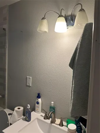 a bathroom with a sink mirror and toilet