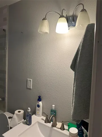 a bathroom with a sink mirror and toilet