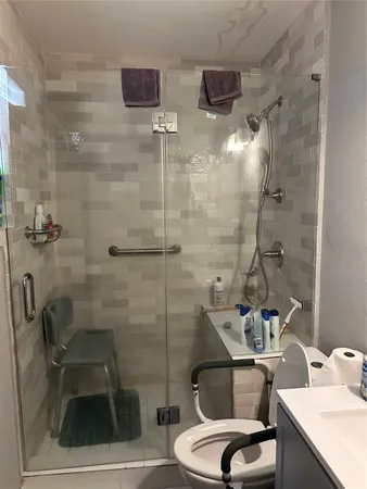 a bathroom with a sink a toilet and shower