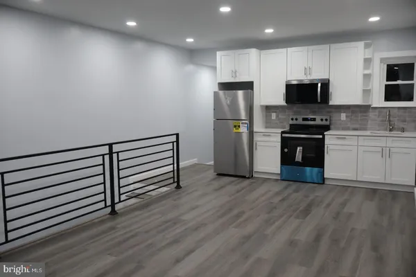 a kitchen with stainless steel appliances a stove top oven a sink and a refrigerator