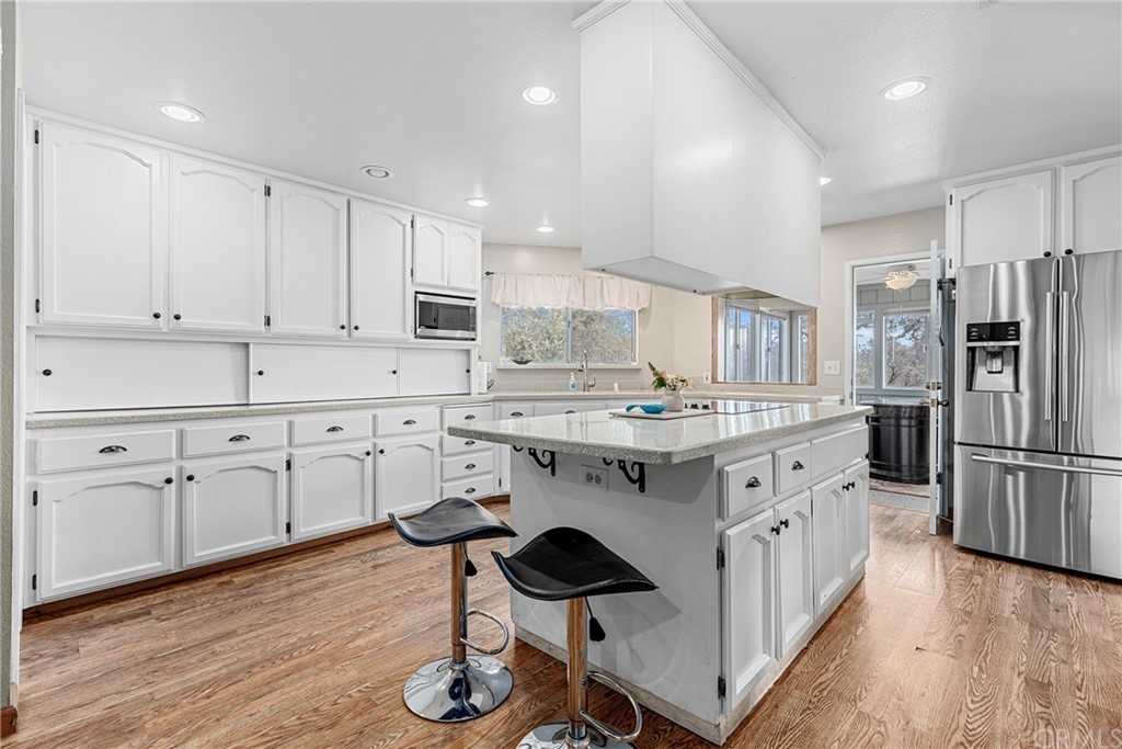 45943 Black Oak Road Coarsegold, CA 93614 - Photo 25 of 64 a kitchen with granite countertop a sink appliances cabinets and wooden floor