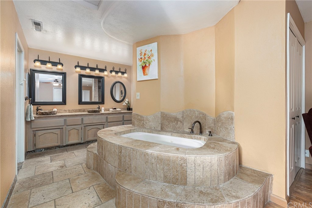 45943 Black Oak Road Coarsegold, CA 93614 - Photo 31 of 64 a bathroom with a granite countertop sink mirror and vanity