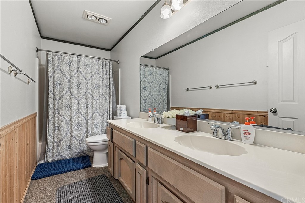 45943 Black Oak Road Coarsegold, CA 93614 - Photo 44 of 64 a bathroom with a sink a toilet a shower curtain and a large mirror